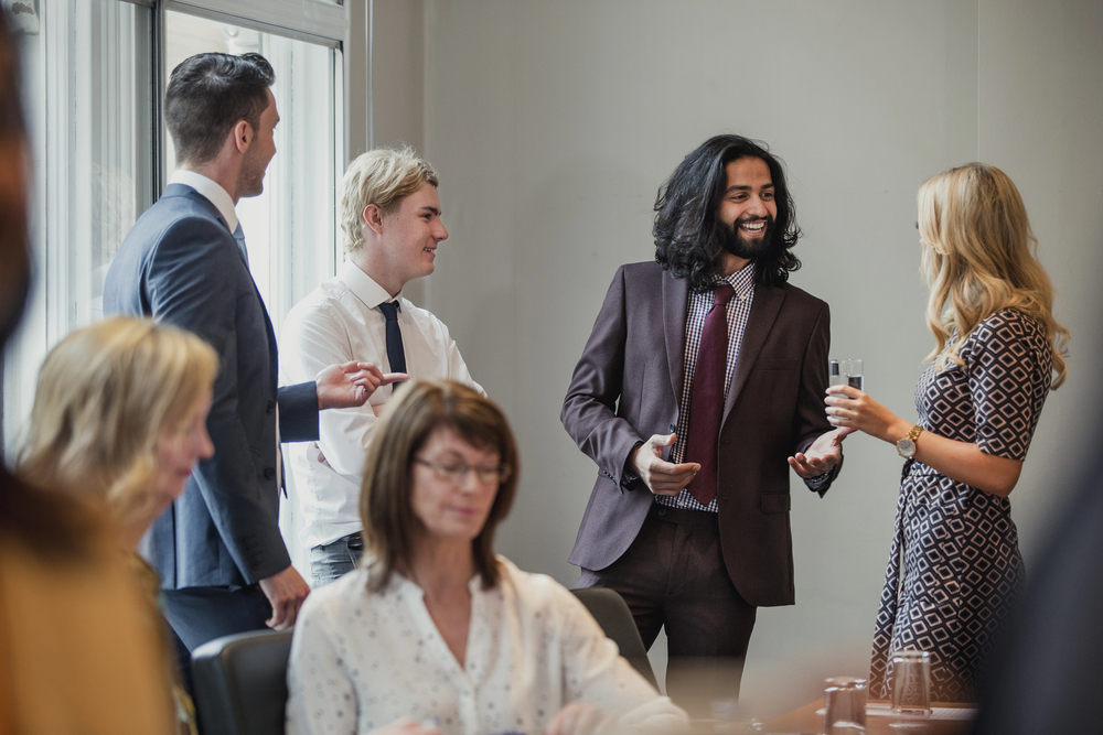 alt= business people talking to each other at a professional networking event 